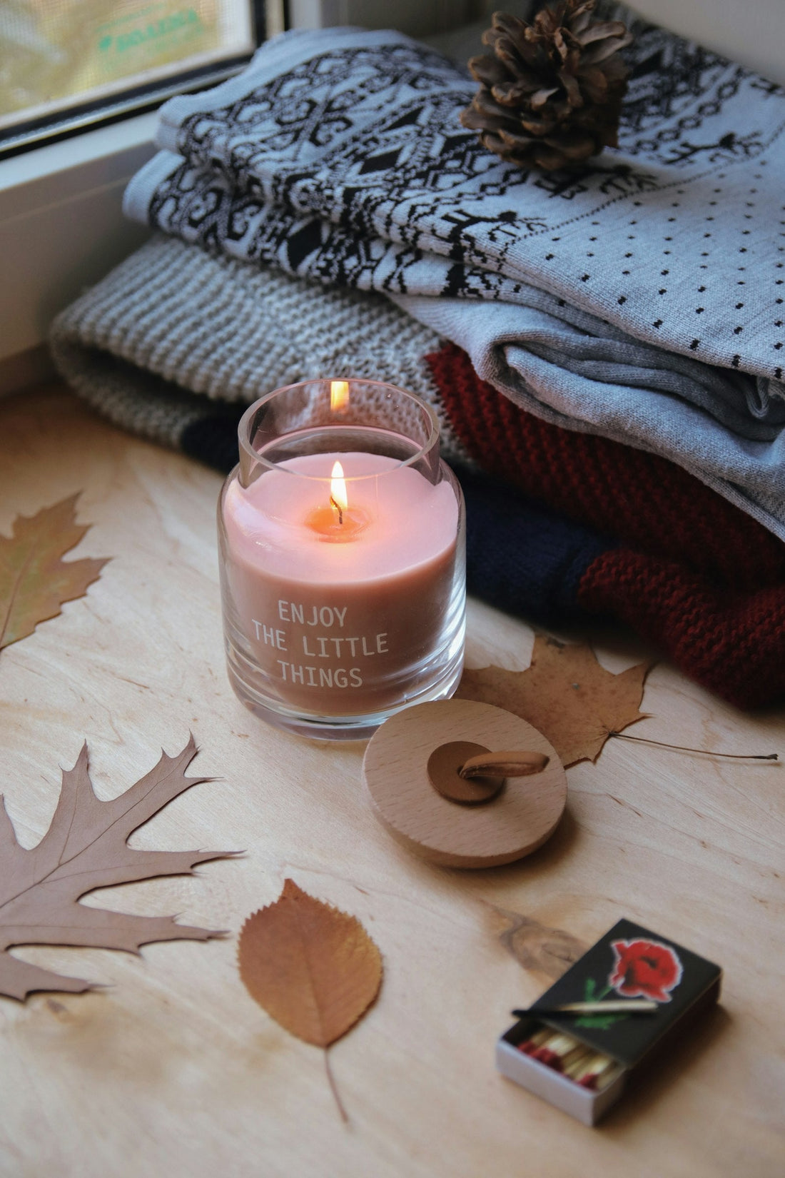 Bougie parfumée rose et plaid tricoté pour une soirée cocooning